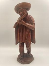 Drewniana figurka mężczyzna grający na drewnianym flecie