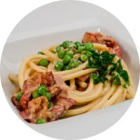 Makaron bucatini z boczkiem i zielonym groszkiem w śmietanowym sosie