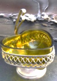 Szklana cukiernica lub bomboniera w kształcie serca w metalowym koszyczku